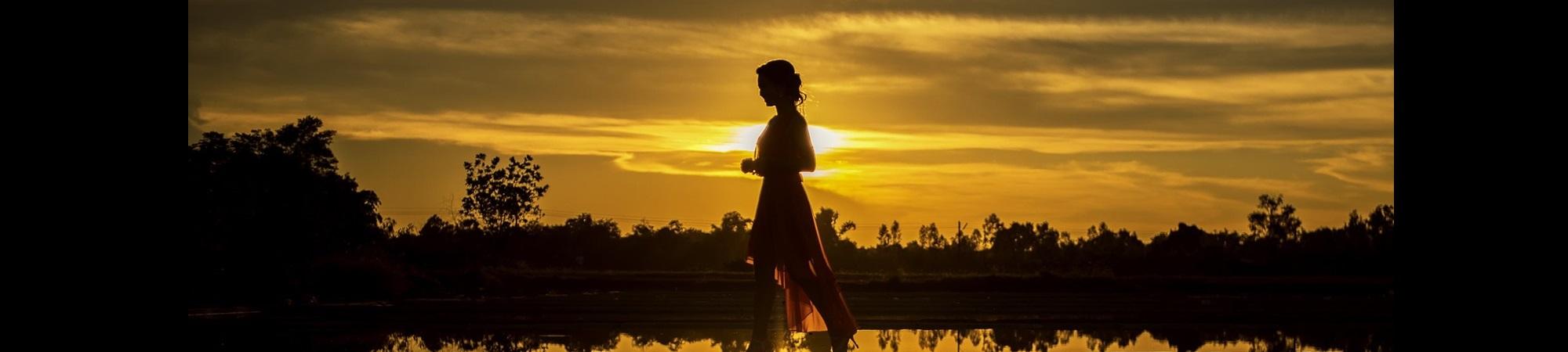 Women walking to the left at sunset